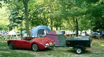 MGA with luggage trailer at campground